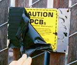 [Photo: PCB warning sign covered up.]